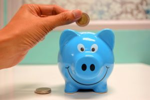 coin being dropped into blue piggybank