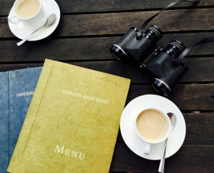 2 hardcover menus with coffee and binoculars