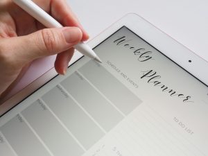 weekly planner on a tablet with hand holding stylus