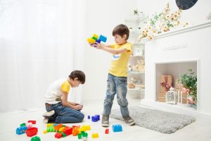 2 young boys playing with colorful blocks