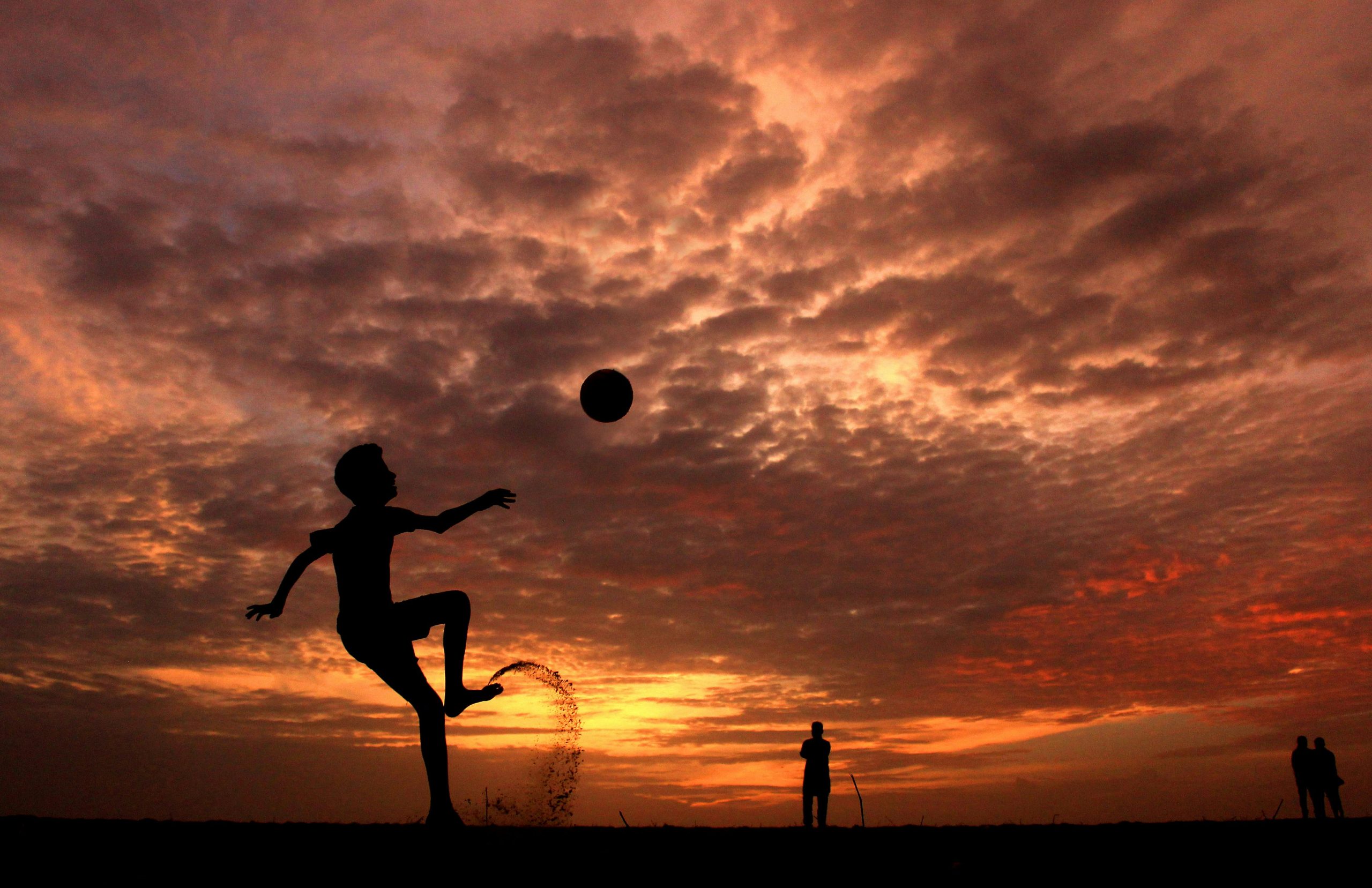 soccer kick against sunset and clouds