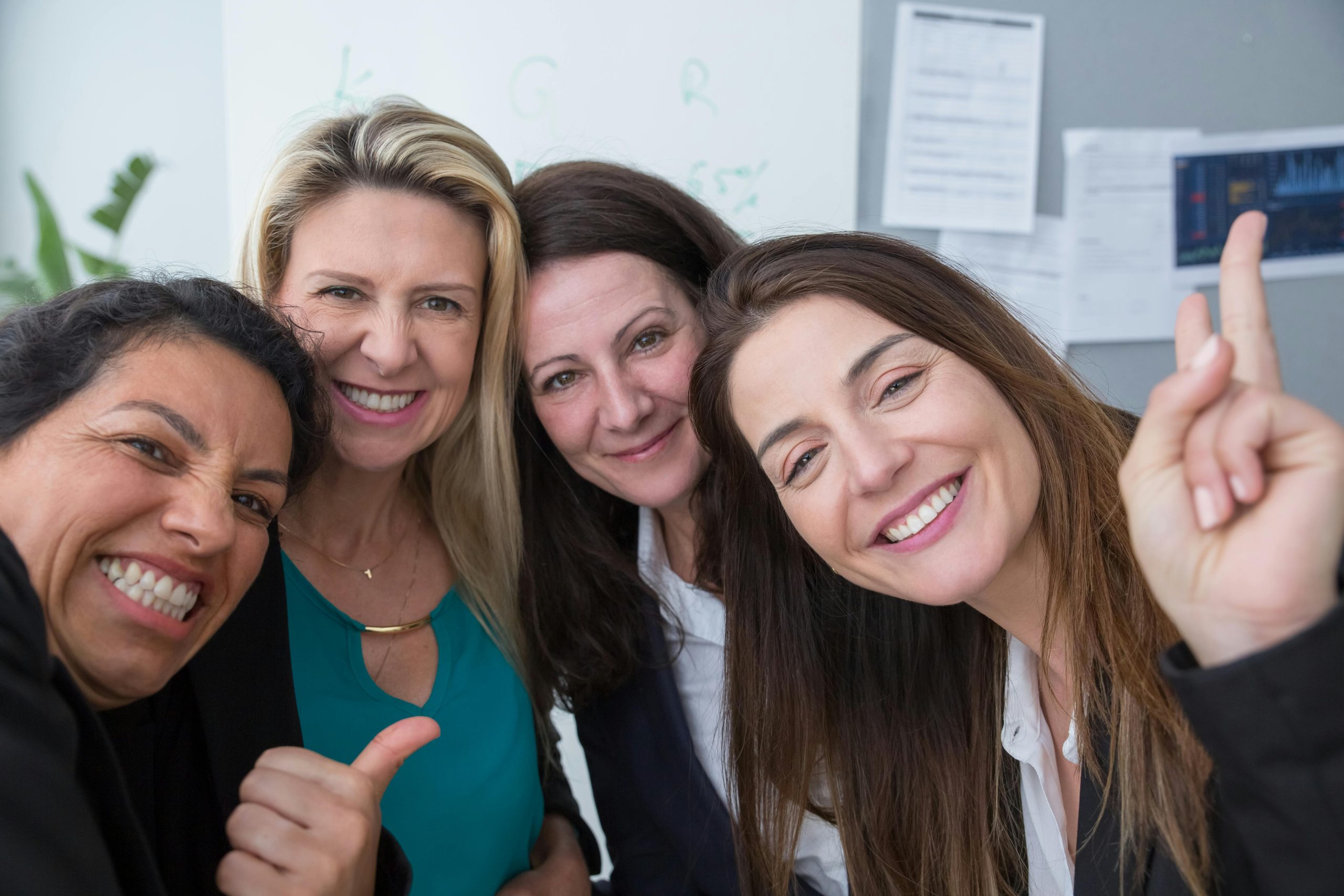 4 women smiling and posing for camera