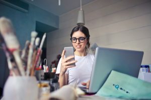 woman on smartphone and laptop