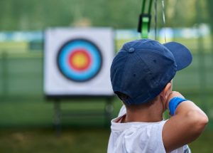boy shooting arrow at target