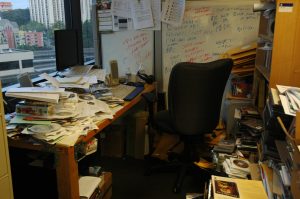 messy desk in corner of room
